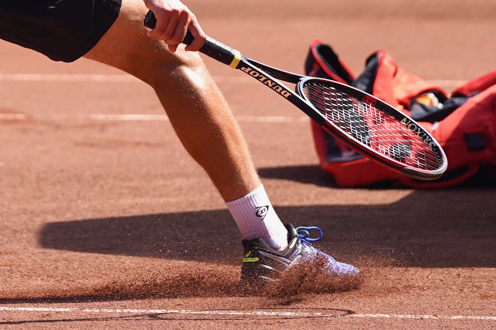 Tennisser glijdt slide op gravel