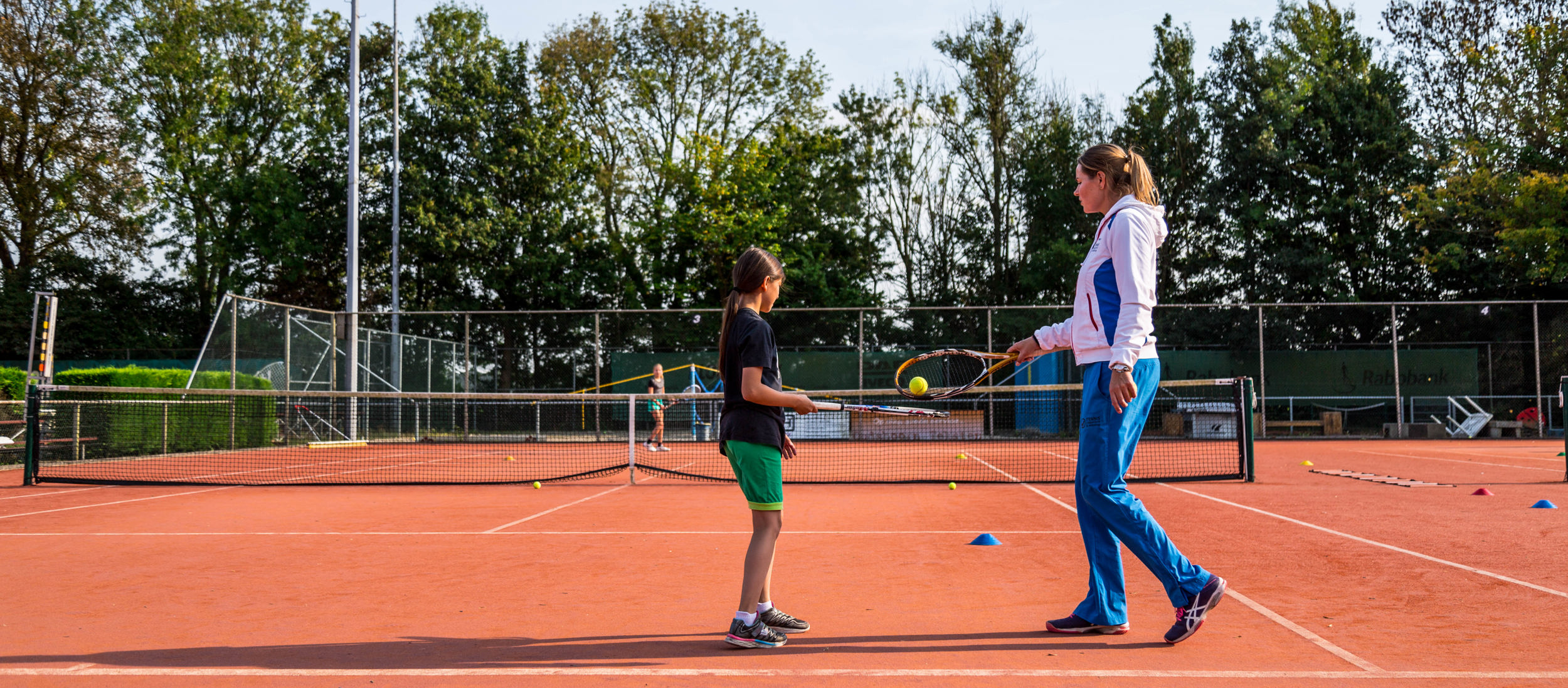 Tennisles leraar met kind